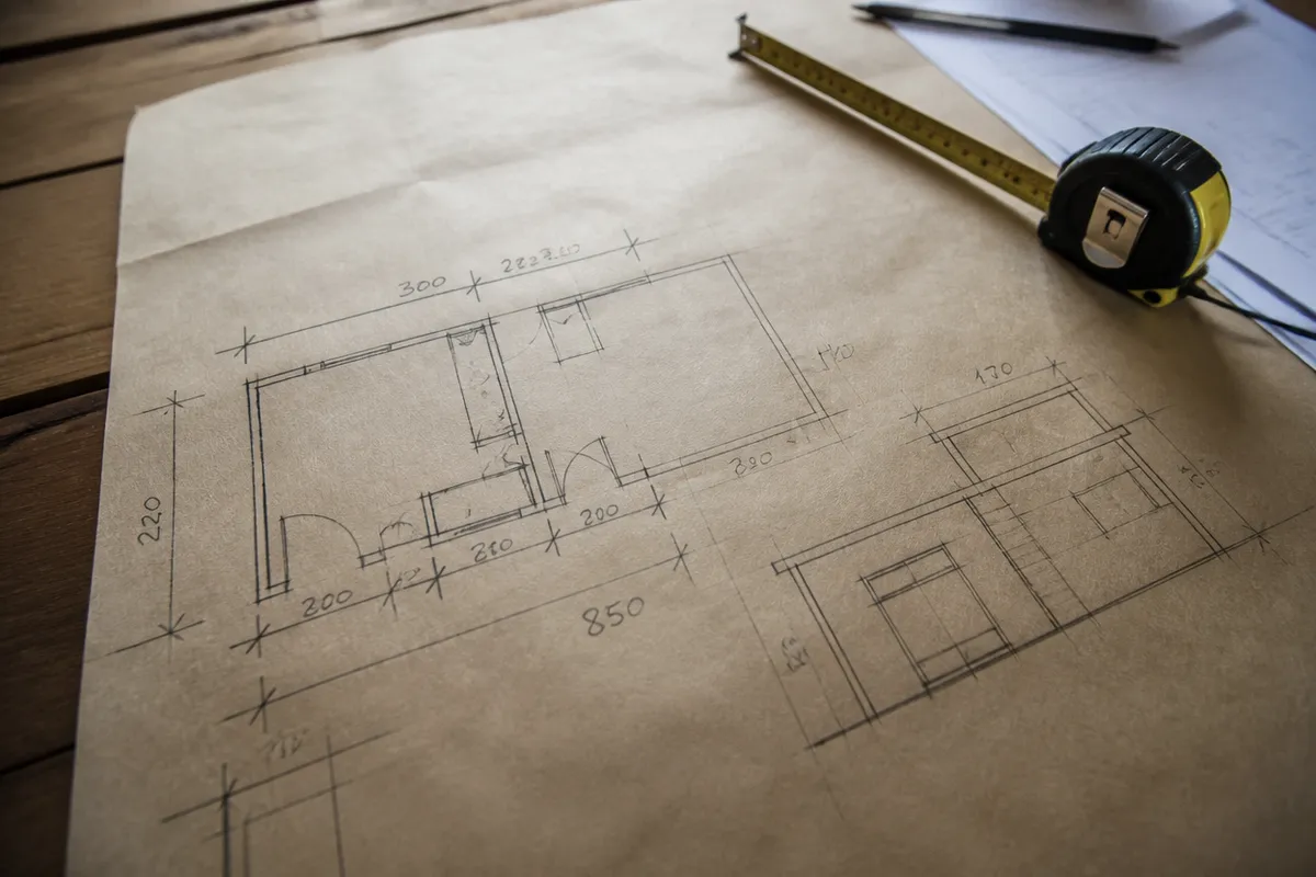 Croquis y mediciones de una vivienda sobre una mesa de trabajo